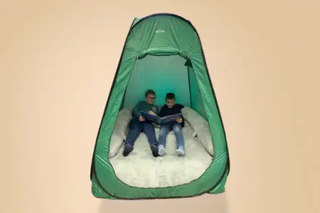 Grünes Rückzugszelt mit weichem Sitzsack – ein ruhiger, reizreduzierter Ort für autistische Kinder zur Entspannung und Overload-Prävention.